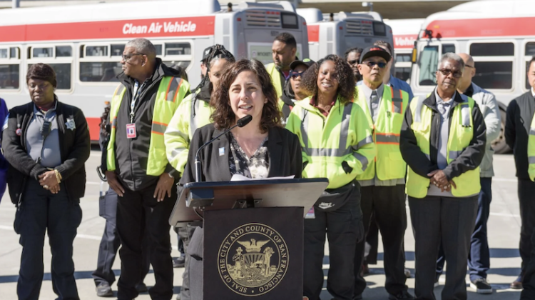 Image of Kirschbaum at a podium with folks in uniform behind her