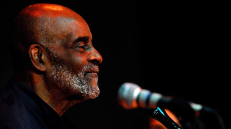 Headshot of Mel King, at a microphone, taken in profile